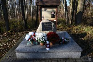 Obelisk Marii Piotrowiczowej w Sosnowcu-Pieńkach udekorowany kwiatami i zniczami