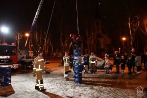Uczestnik konkursu wspina się na wieżę zbudowaną z plastikowych skrzynek, obok strażacy OSP Kiełmina, obserwatorzy 31...