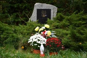 Mogiła żołnierska udekorowana kwiatami i zniczami