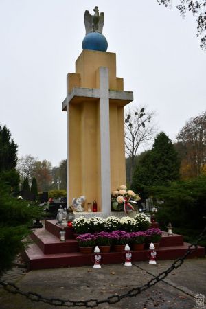 Pomnik w Dobrej udekorowany kwiatami i zniczami