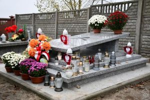 Mogiła żołnierska na cmentarzu mariawickim w Strykowie udekorowana kwiatami i zniczami