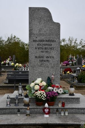 Pomnik Bohaterom Powstania Styczniowego udekorowany kwiatami i zniczami
