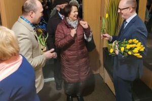 Burmistrz Strykowa wręcza tulipany paniom wychodzącym z sali DK