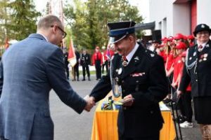 Burmistrz Strykowa Witold Kosmowski wręcza pamiątkowy grawerton Prezesowi OSP w Strykowie Szymonowi Sitkowi.
