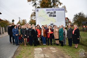 Mieszkańcy Niesułkowa oraz zaproszeni goście przy tablicy informacyjnej wraz z mapą i rysem historyczno-fotograficznym...
