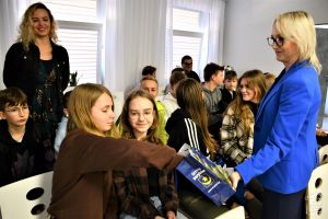 Zastępca Burmistrza Strykowa Tamara Barańska-Kiemaczyńska częstuje uczniów promocyjnymi cukierkami Gminy Stryków. Wraz z...