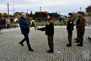 Kwiaty składa przedstawiciel PiS Koło Terenowe w Strykowie Tadeusz Rosiński.