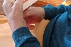 Senior trzymający w dłoniach kartkę z życzeniami