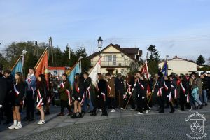 Poczty sztandarowe szkół w przemarszu pod Pomnik Niepodległości w Strykowie