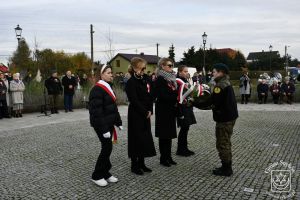 Kwiaty składa delegacja SP Nr 2 w Strykowie z Dyrektor Małgorzatą Ciesielską.