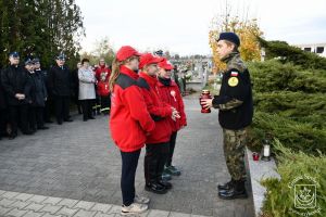 Delegacja MDP OSP Stryków pod pomnikiem żołnierzy poległych w 1918 r. i 1939 r. na cmentarzu rzymskokatolickim w Strykowie