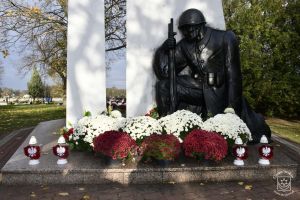 Pomnik "Bohaterom Walk nad Bzurą w Koźlu" ozdobiony kwiatami i zniczami