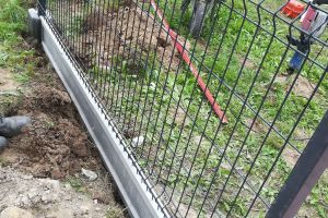 Wymiana ogrodzenia placu zabaw przy SP1 w Strykowie, w trakcie montowania ogrodzenia